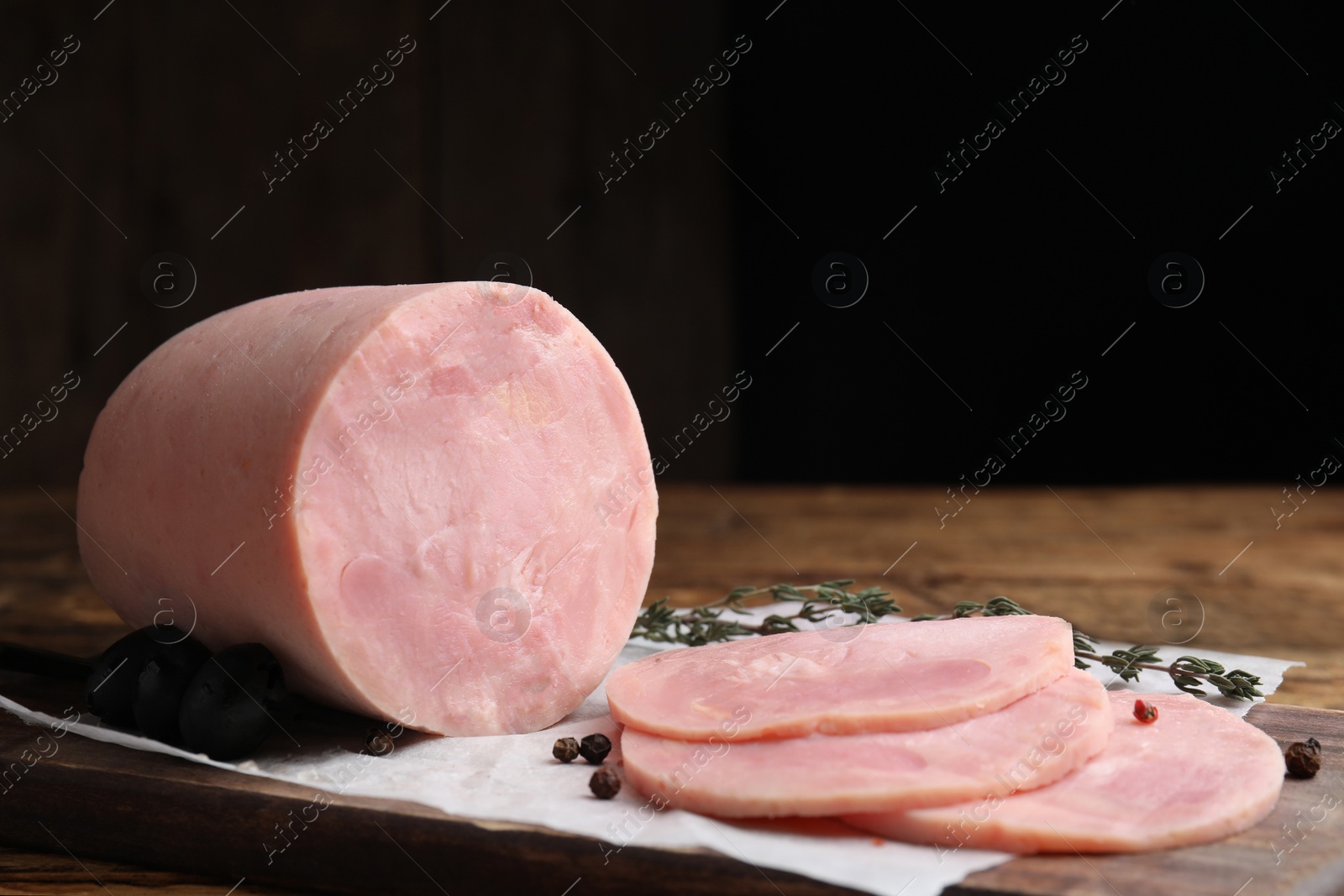 Photo of Tasty ham with thyme and pepper on wooden table