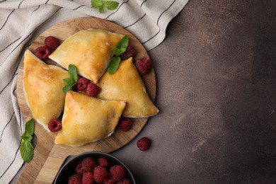 Photo of Delicious samosas with raspberries on grey table, flat lay. Space for text