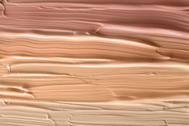 Different shades of liquid foundation as background, closeup