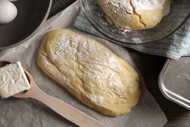 Photo of Raw dough, eggs and flour on wooden table, flat lay. Cooking ciabatta