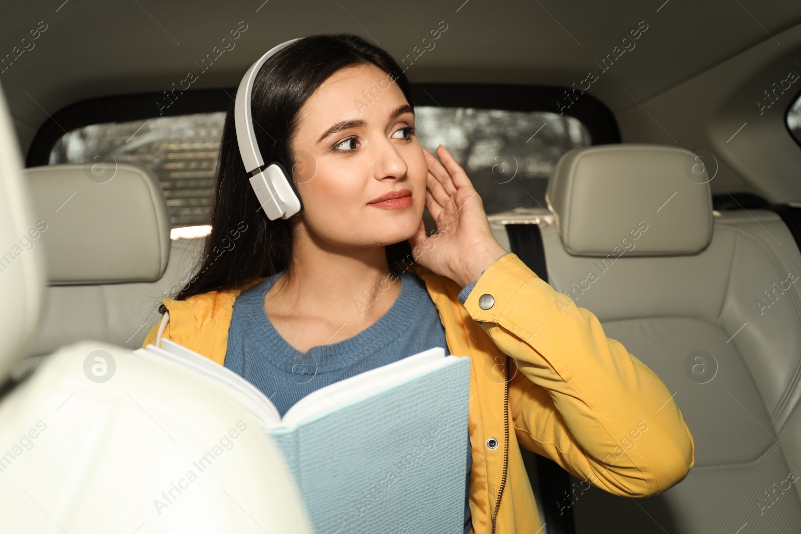 Photo of Young woman listening to audiobook in car