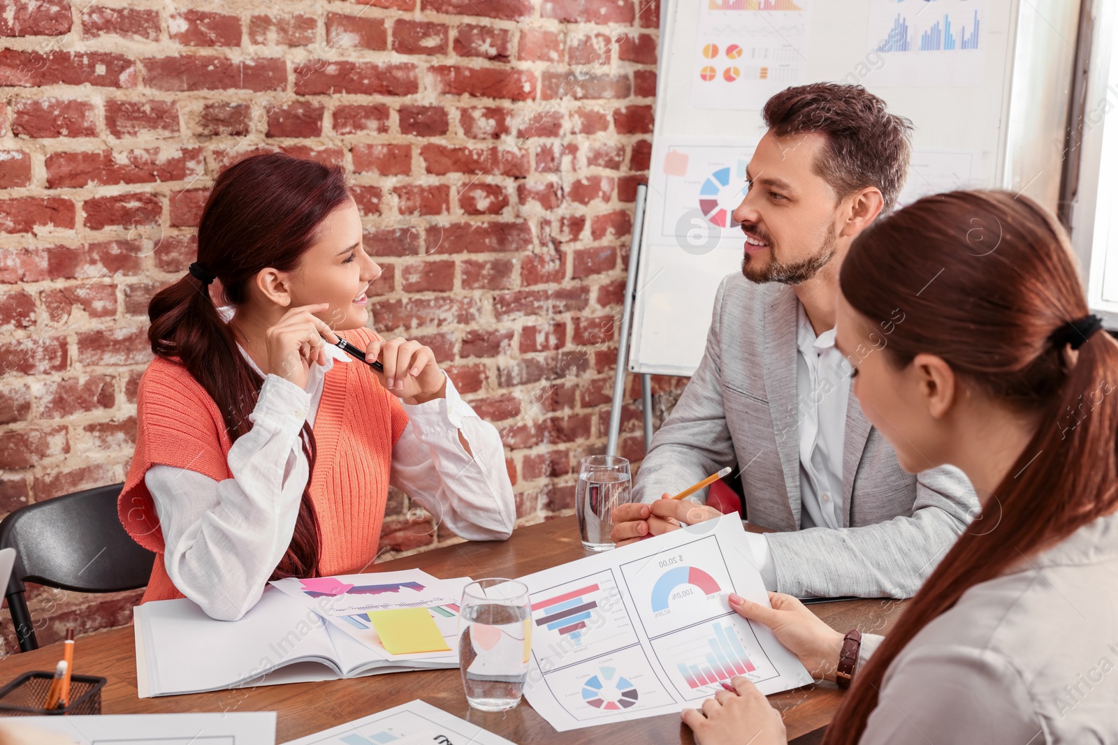 Photo of Team of employees working together in office