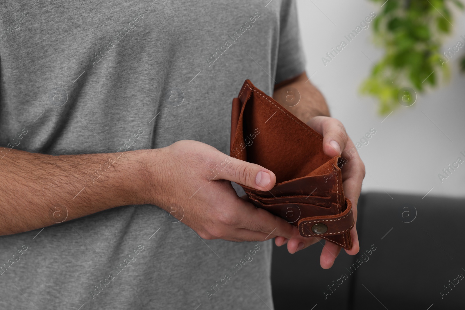 Photo of Man with empty wallet at home, closeup