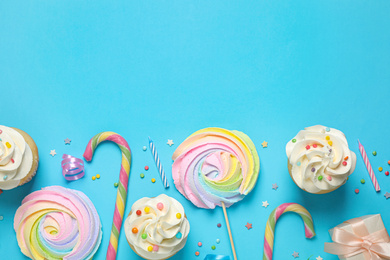 Flat lay composition with cupcakes on light blue background, space for text. Birthday party