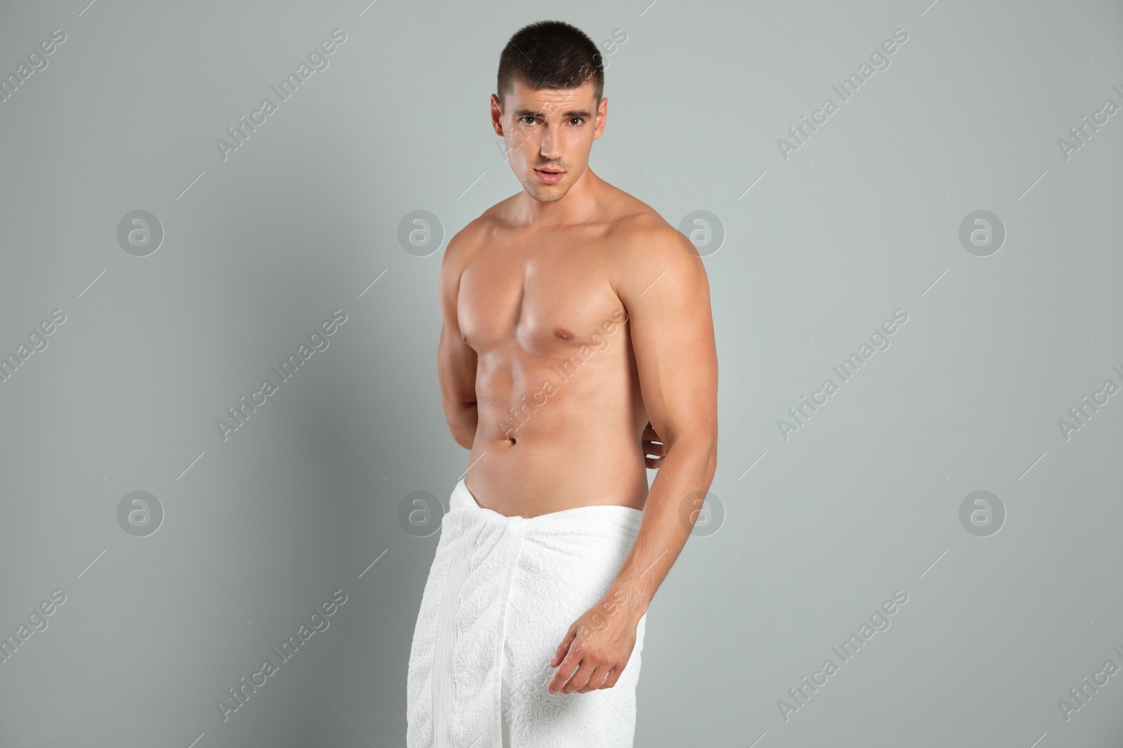 Photo of Young man with slim body on grey background