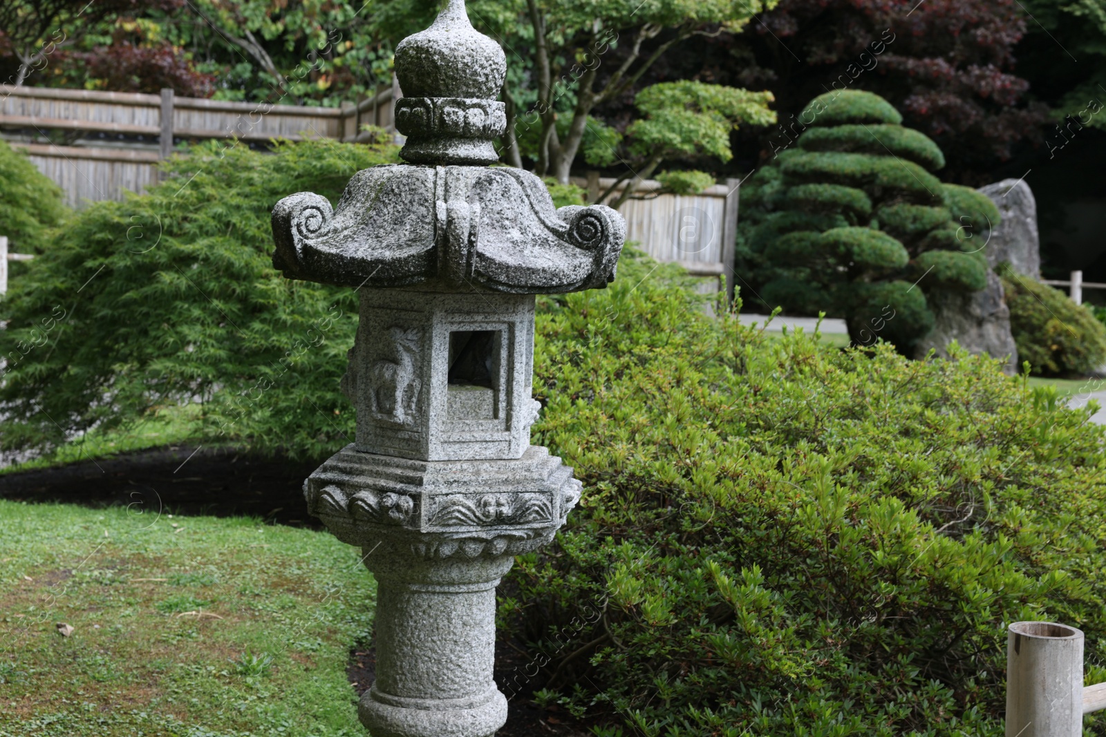 Photo of Beautiful stone streetlight and green plants in park