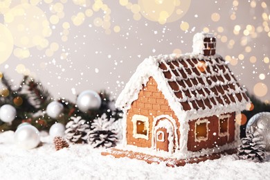 Image of Beautiful gingerbread house decorated with icing on snow, space for text