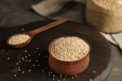 Bowl with white quinoa on wooden board. Space for text