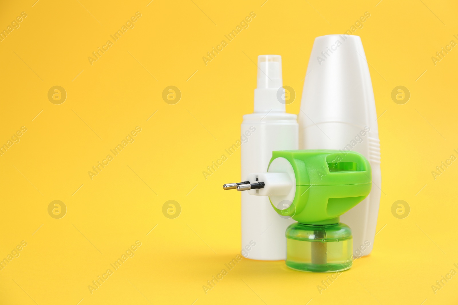 Photo of Set of different insect repellents on yellow background. Space for text