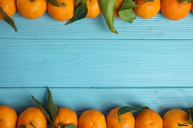 Fresh ripe tangerines and space for text on wooden background, top view