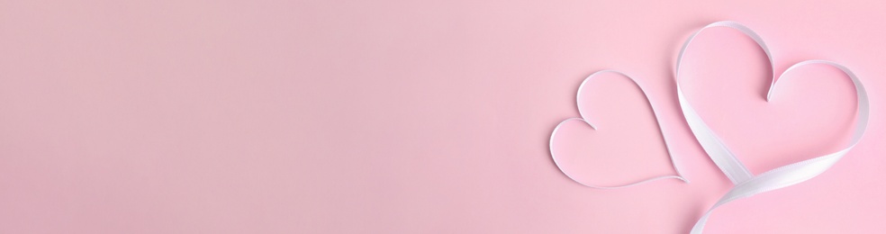 Image of Hearts made of white ribbon on pink background, flat lay. Valentine's Day banner design