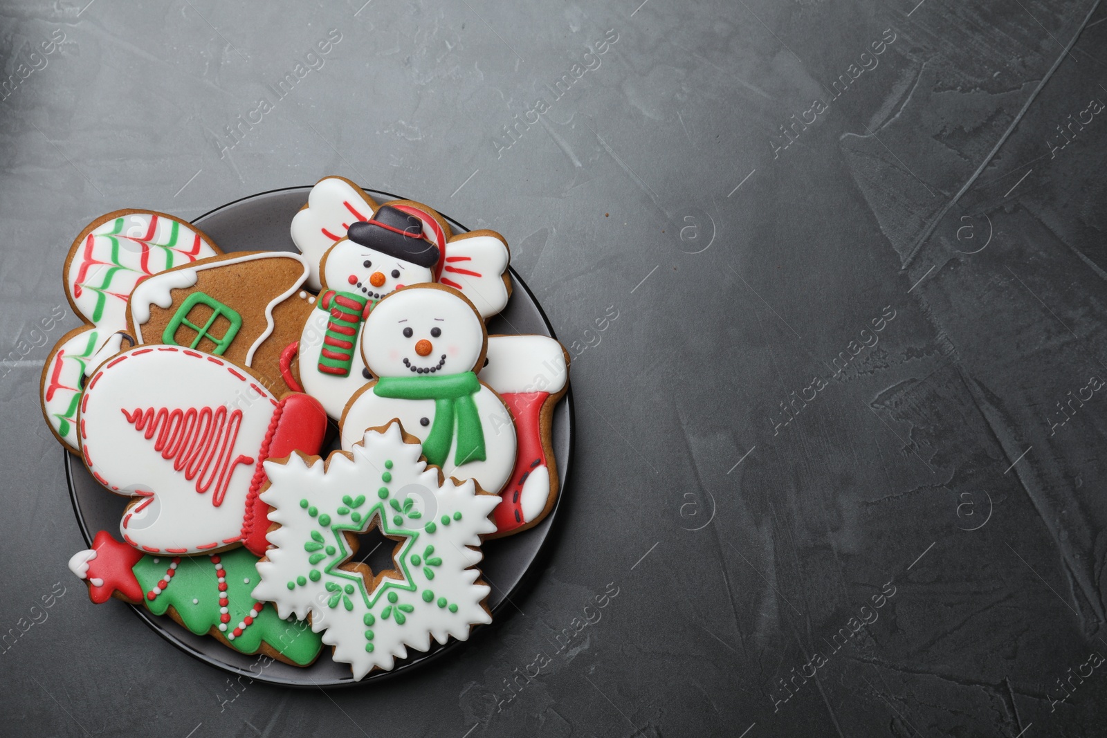 Photo of Delicious Christmas cookies on black table, top view. Space for text