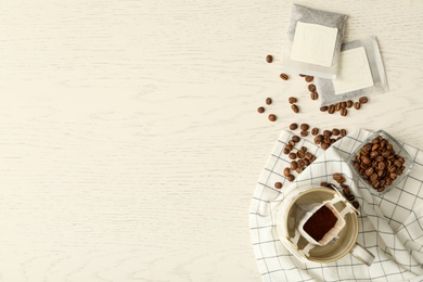 Photo of Flat lay composition with drip coffee bags on white wooden table. Space for text