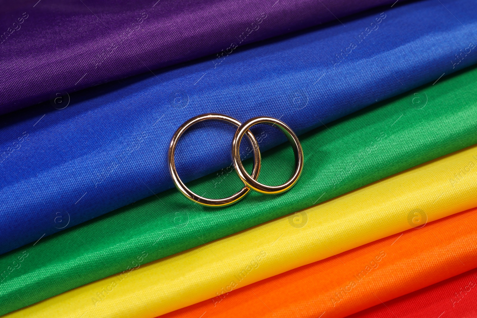 Photo of Wedding rings on rainbow LGBT flag, top view