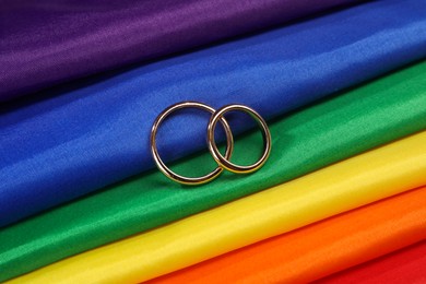 Wedding rings on rainbow LGBT flag, top view