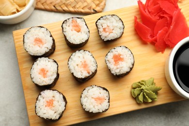 Photo of Tasty sushi rolls served on grey table, flat lay