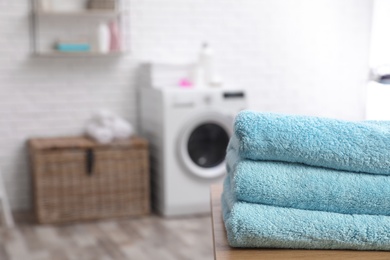 Photo of Stack of towels on table against blurred background, space for text