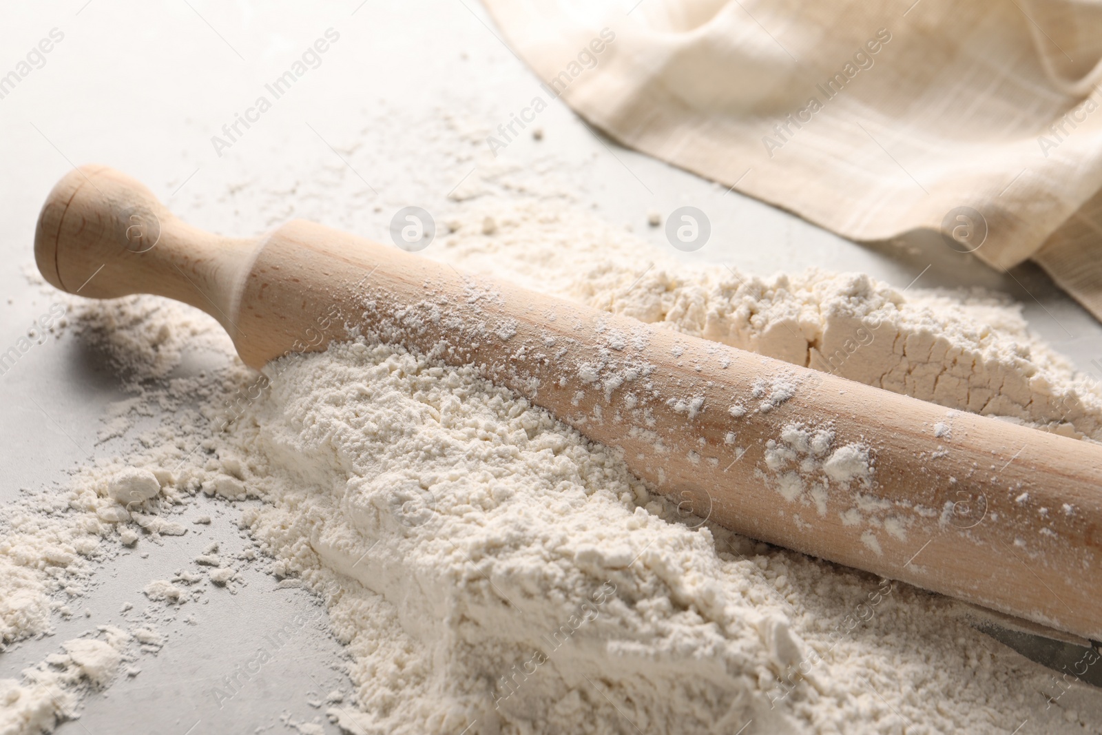 Photo of Pile of flour and rolling pin on table, closeup