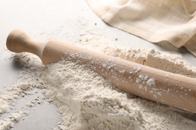 Photo of Pile of flour and rolling pin on table, closeup