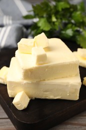 Photo of Pieces of tasty butter on wooden table