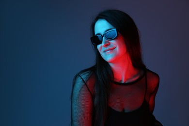 Portrait of beautiful young woman with sunglasses on color background. Space for text