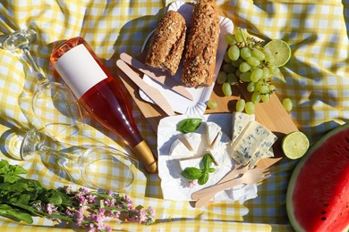 Photo of Delicious food and wine on picnic blanket, flat lay