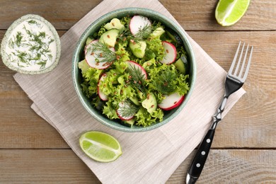 Delicious salad with radish, cucumber and lettuce served on wooden table, flat lay