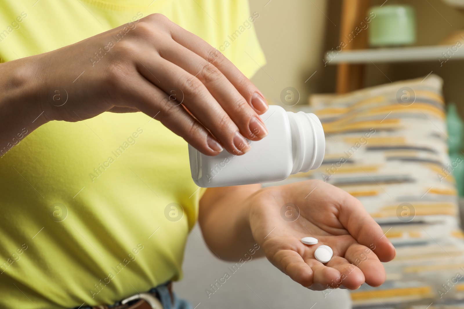 Photo of Woman pouring pills from bottle indoors, closeup. Menopause concept