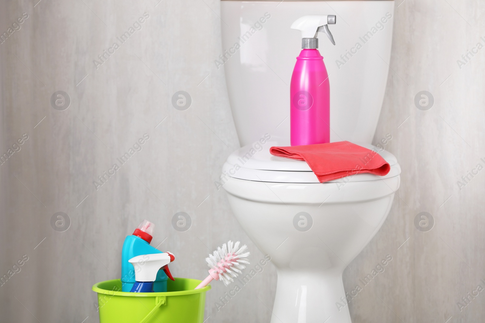 Photo of Different cleaning supplies and toilet bowl indoors