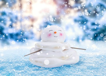 Image of Cute decorative snowman outdoors on snowy day