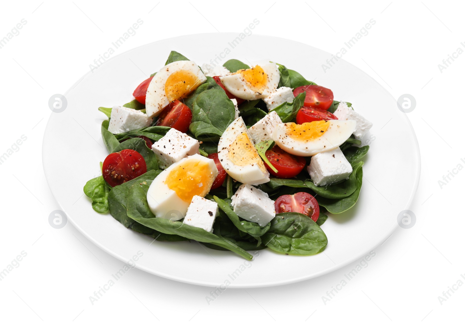 Photo of Delicious salad with boiled eggs, feta cheese and tomatoes isolated on white