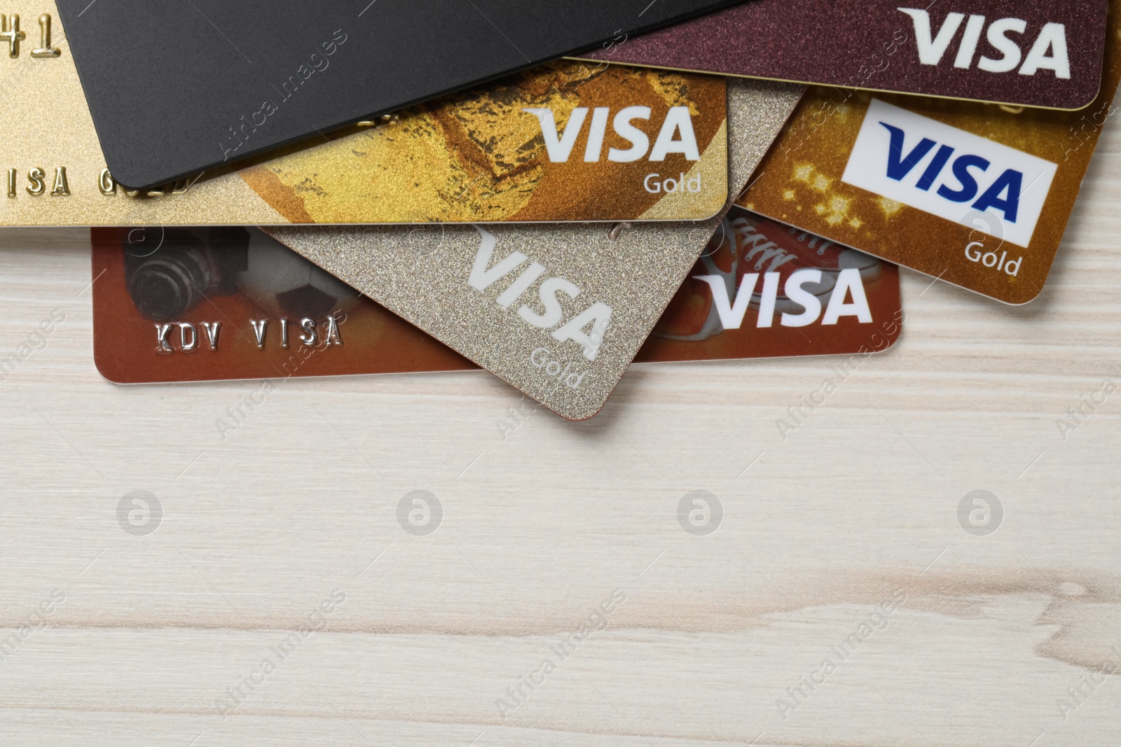 Photo of MYKOLAIV, UKRAINE - FEBRUARY 22, 2022: Visa credit cards on white wooden table, flat lay. Space for text