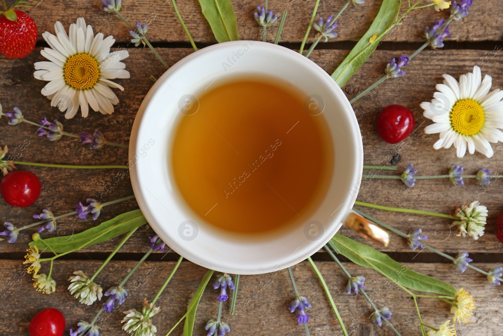 Photo of Tasty herbal tea, flowers and fruits on wooden table, flat lay
