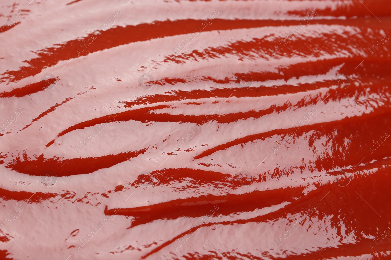 Photo of Tasty ketchup as background, closeup. Tomato sauce