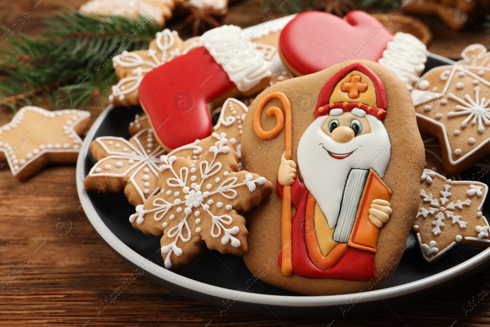 Photo of Tasty gingerbread cookies on wooden table, closeup. St. Nicholas Day celebration