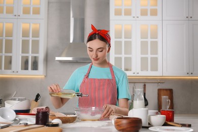 Photo of Beautiful woman cooking in kitchen. Dirty dishware, food leftovers and utensils on messy countertop