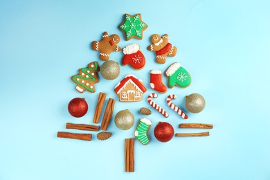 Photo of Christmas tree shape made of tasty homemade cookies on color background, top view