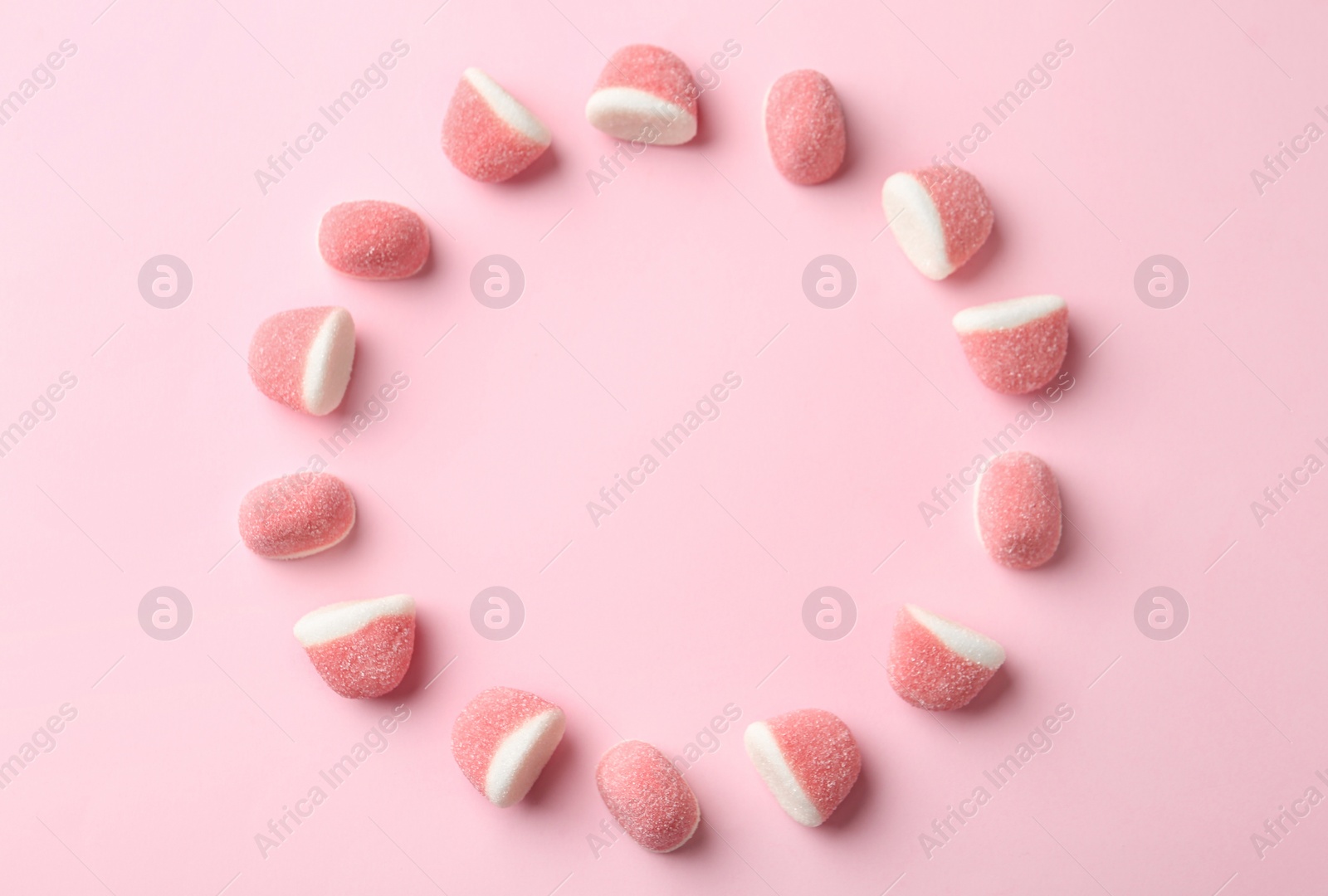 Photo of Frame of sweet jelly candies on pink background, flat lay. Space for text