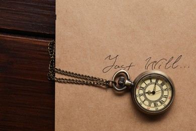 Paper with words Last Will and pocket watch on wooden table, top view