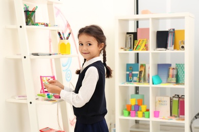 Cute child choosing school stationery in store