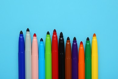 Photo of Many different colorful markers on light blue background, flat lay