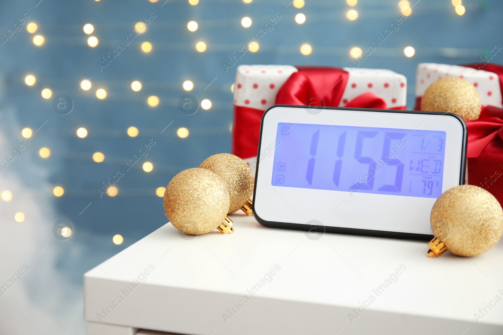 Photo of Electric clock, gifts and festive decor on table. Christmas countdown