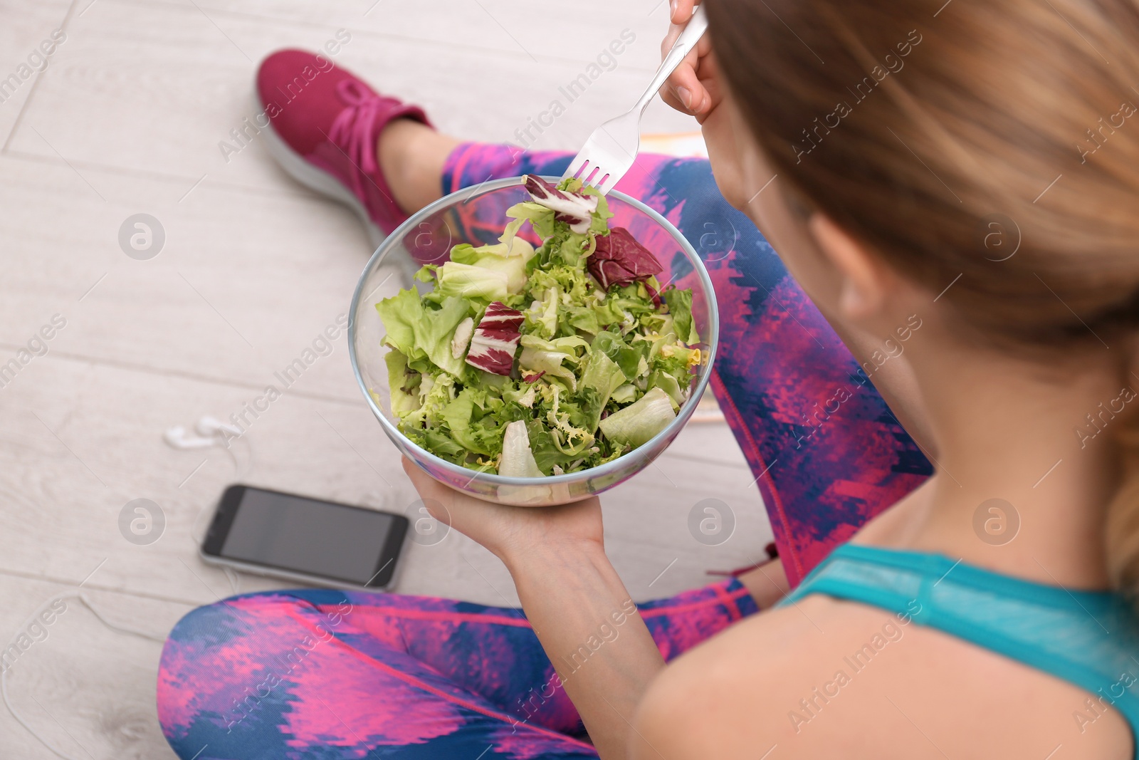 Photo of Young woman in fitness clothes having healthy breakfast at home, closeup