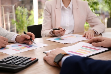 Photo of Business people working with charts and graphs at table in office, closeup. Investment analysis