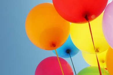 Photo of Bright colorful balloons against blue sky, closeup
