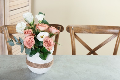 Photo of Vase with beautiful flowers as element of interior design on table in room. Space for text