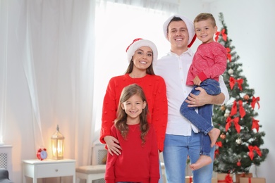 Photo of Happy parents celebrating Christmas with children at home