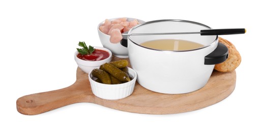 Photo of Oil in fondue pot, fork, pieces of raw meat, pickles and sauce isolated on white