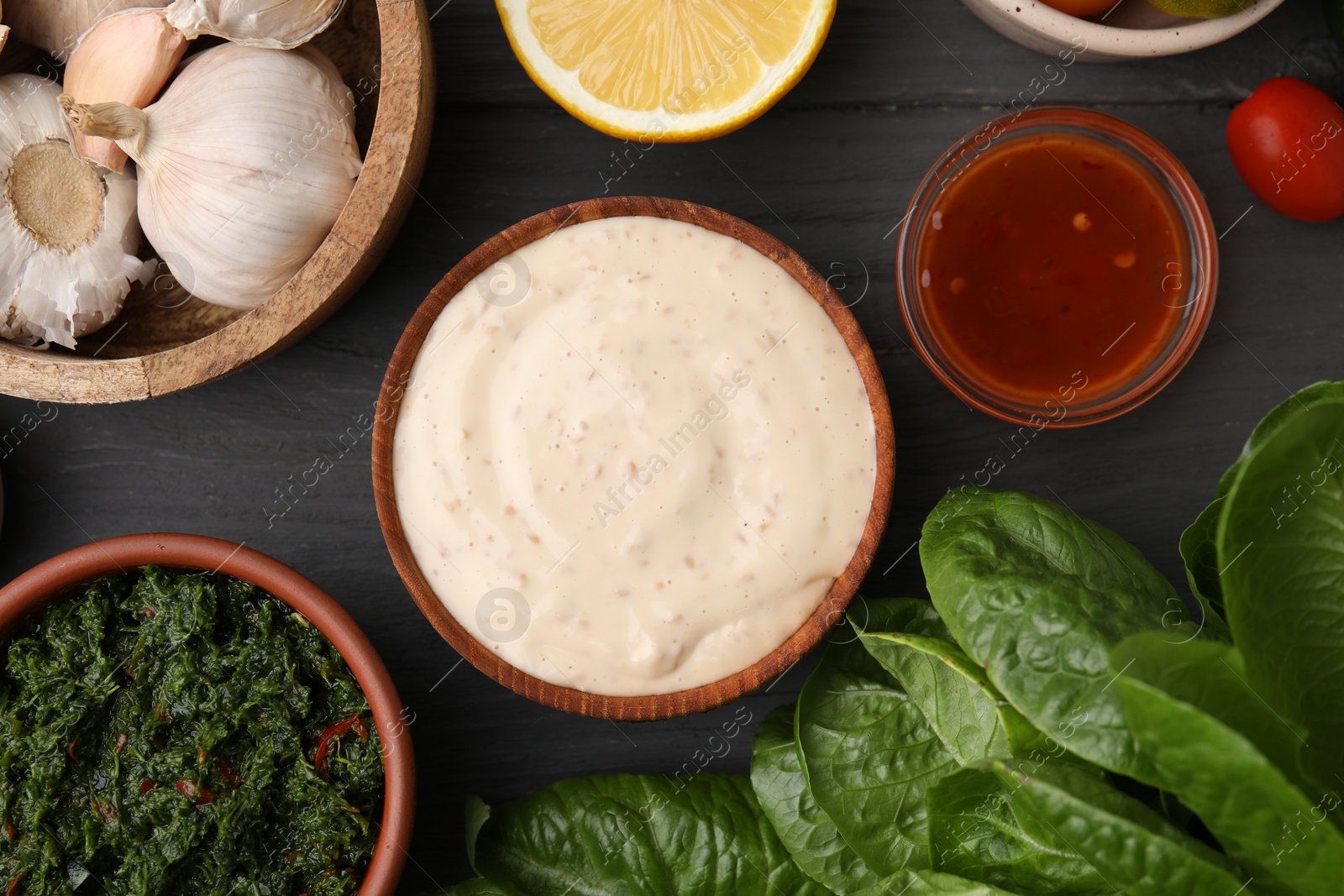 Photo of Different fresh marinades in bowls and ingredients on grey wooden table, flat lay