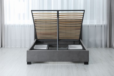 Photo of Modern bed with storage space for bedding under lifted slatted base in room